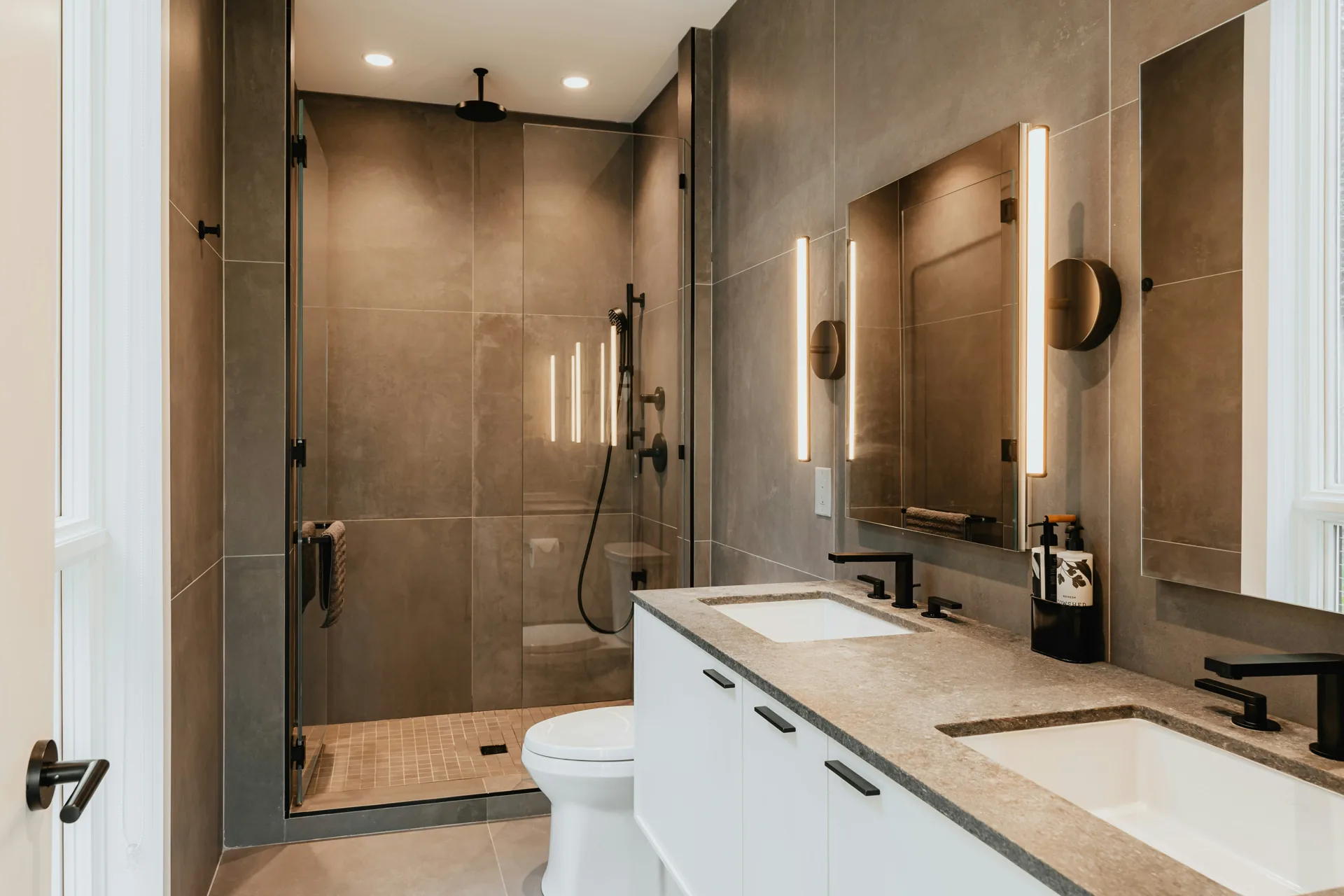 Trending bathroom colors for 2026 — warm taupe bathroom with white vanity by Serden Group